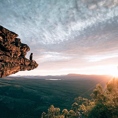 Person Sitting on Cliff